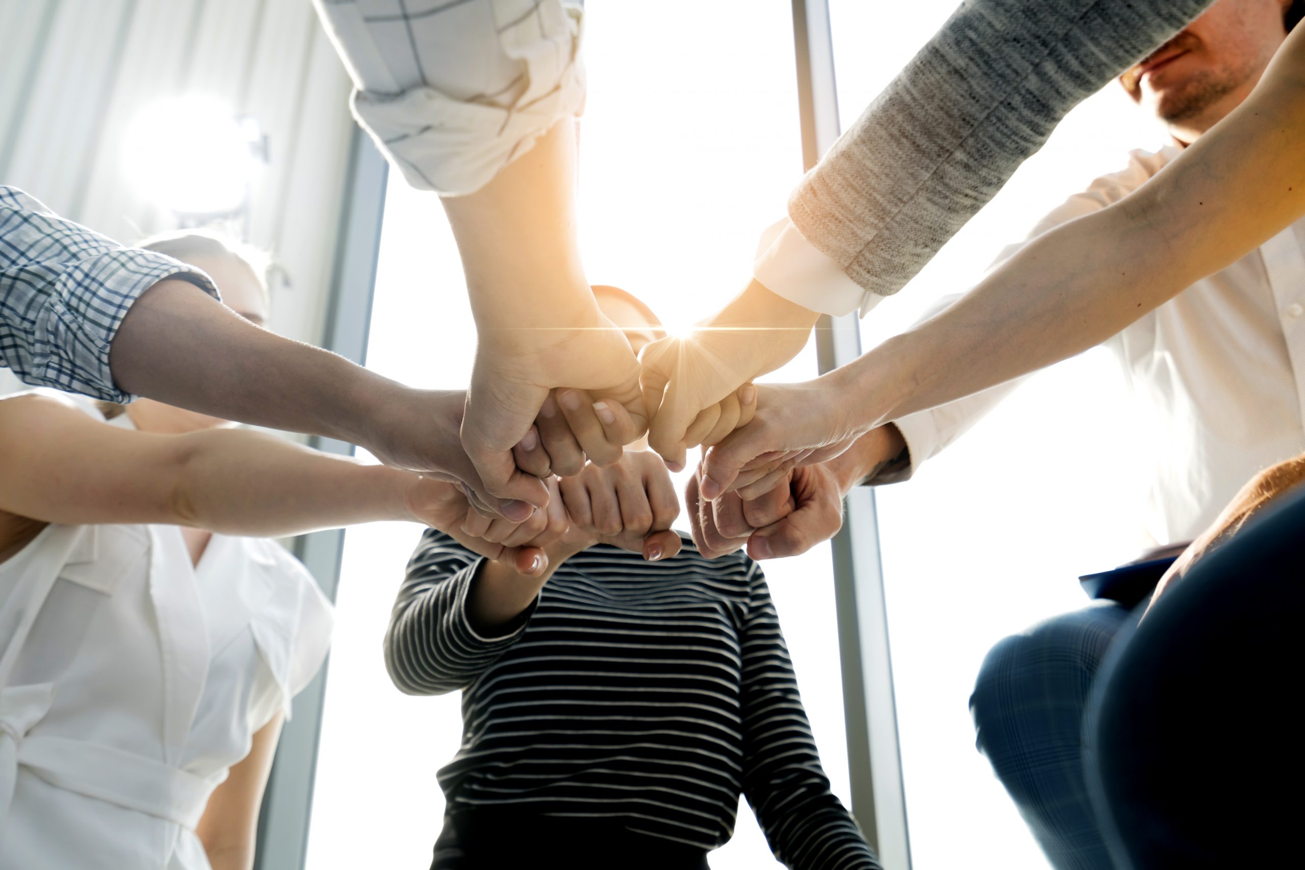 Close up top view of young and freshness energy business people putting their strong hands together. Stack of friendship hands. Unity and successful teamwork concept.